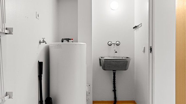 Praktisk separat vaskerom med utslagsvask, opplegg for vaskemaskin og varmtvannsbereder.