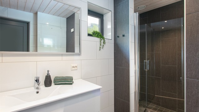Badet er innredet med vegghengt toalett, innfelte spotter i tak og opplegg for kombinert vaskemaskin/tørketrommel som medfølger