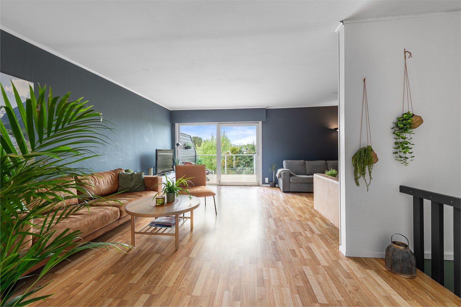 Romslig stue med plass til flere salonger, samt utgang til solrik terrasse mot vest. 