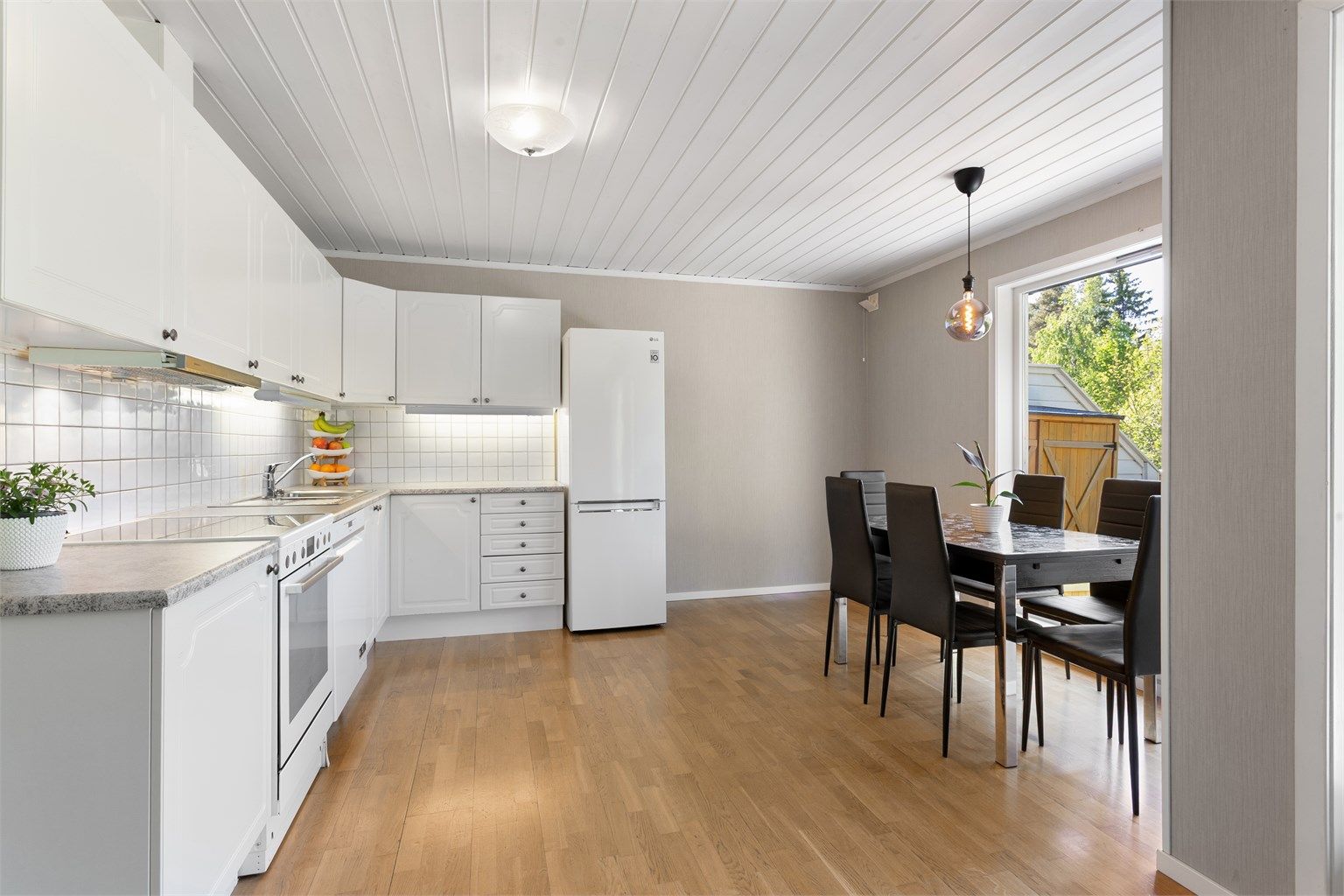 Ende rekkehus - Kjøkken med mye lys fra store vinduer ut mot terrasseplattingen og god plass for spisestue