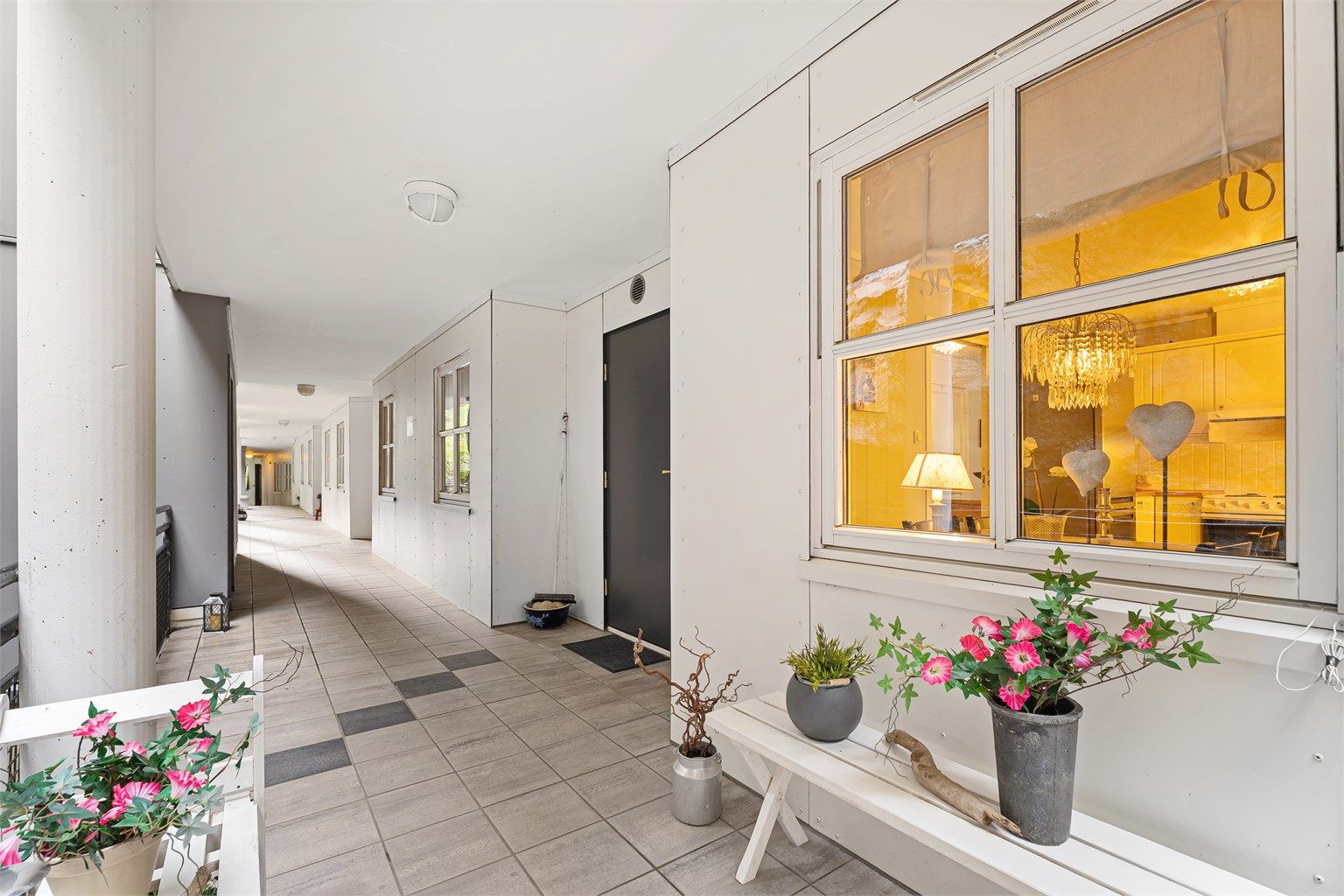 Et svært hyggelig og praktisk overbygd og flislagt inngangsparti 