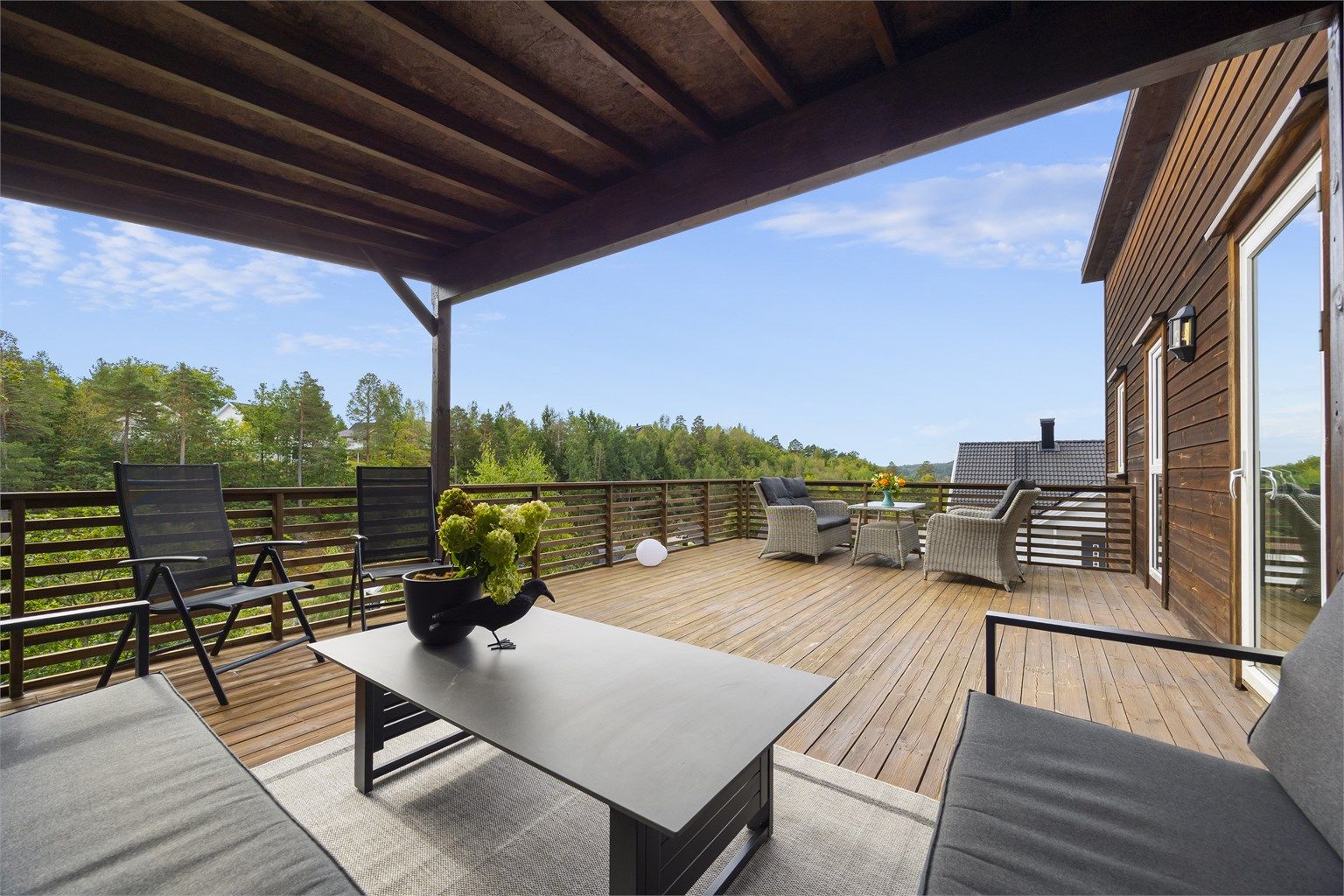Terrassen har både en romslig overbygd del og et åpent dekke med god plass til flere sittegrupper.