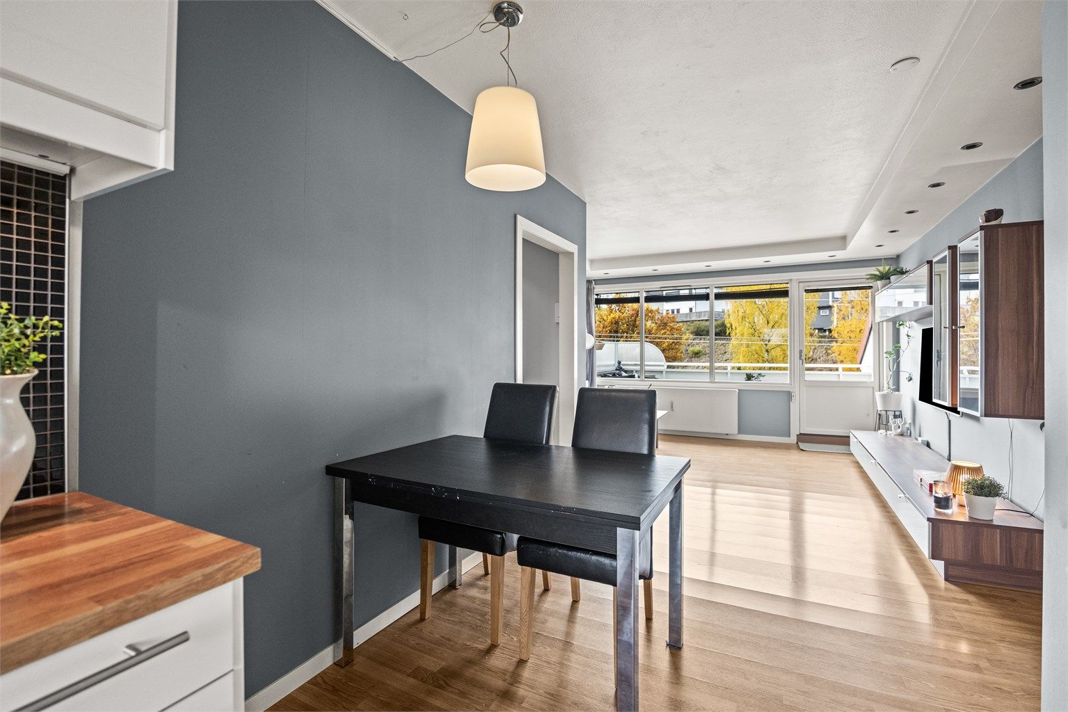 Spiseplass i åpen tilknytning til kjøkkenet med godt lysinnslipp fra vindusrekken.