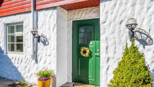 Eneboligen ble oppført i 1991 og har en sjarmerende fasade med pussede murvegger og liggende bordkledning på gavlveggene - velkommen inn.
