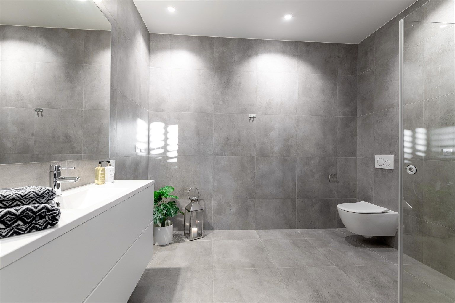 Romslig bad i underetasjen med servantinnredning, speilskap, dusjhjørne og vegghengt toalett. Det er også mulighet for opplegg av vaskemaskin her