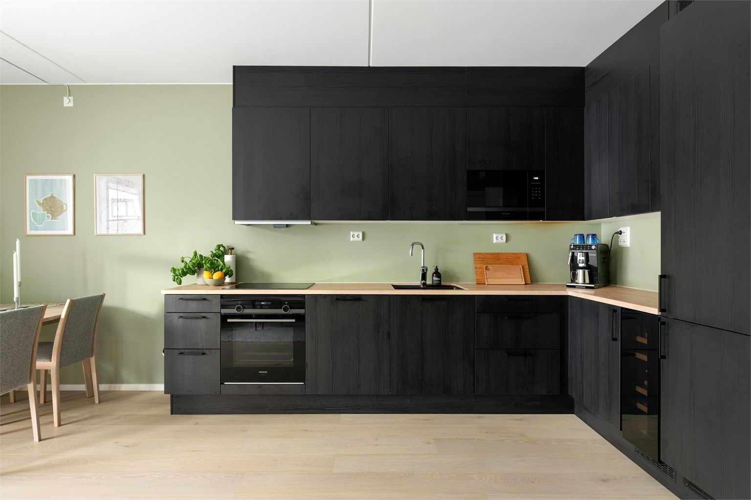 Kjøkkenet har glatte finérdører i mørk brunt eikemønster, med benkeplate i lys eik med underlimt oppvaskkum