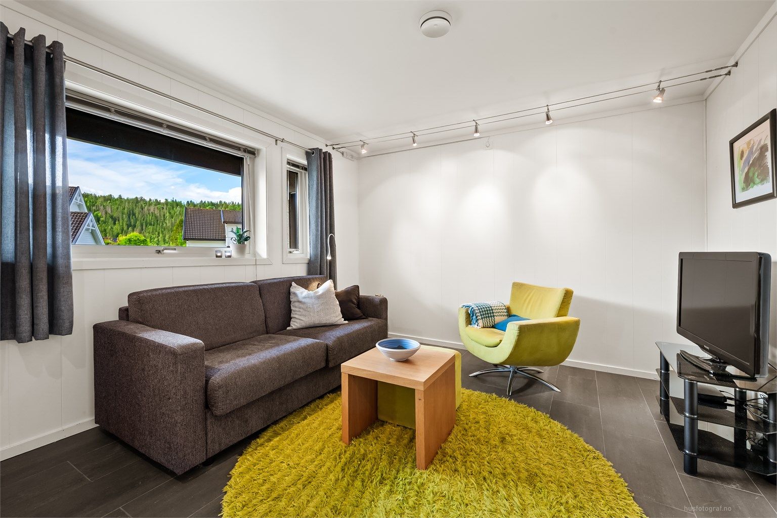 Kjellerstue med flislagt gulv og gulvvarme, et perfekt ekstra oppholdsrom for familien.