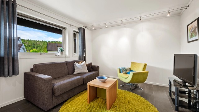 Kjellerstue med flislagt gulv og gulvvarme, et perfekt ekstra oppholdsrom for familien.