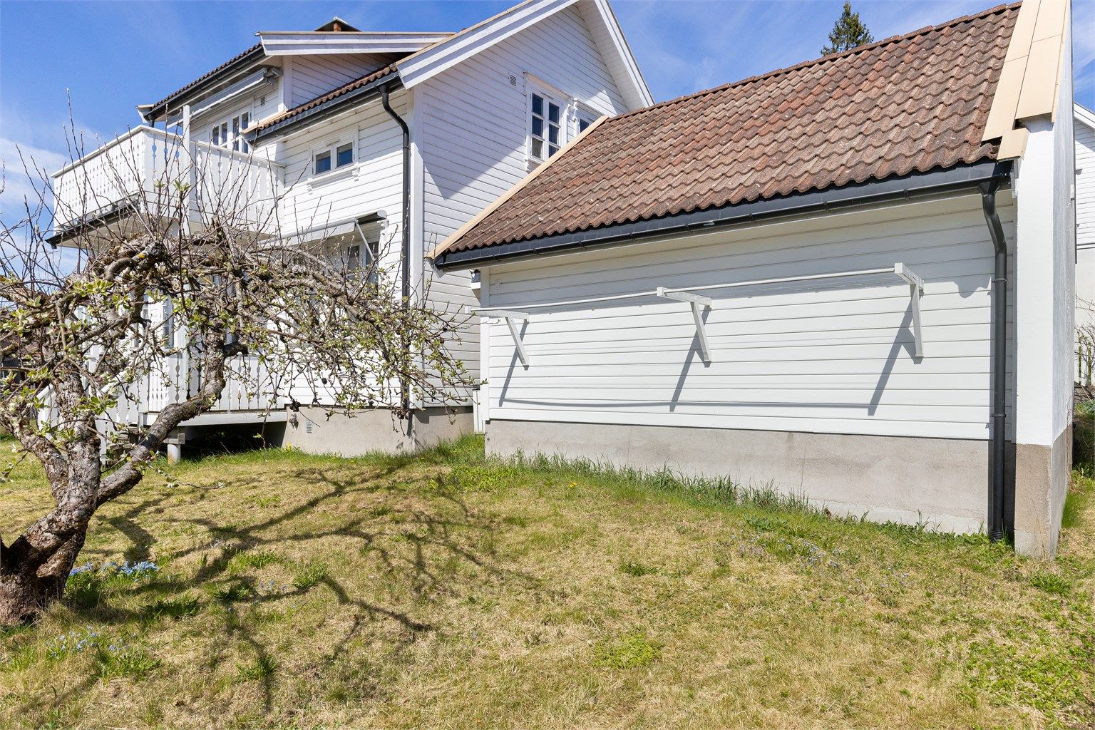 Veggmontert tørkestativ på baksiden av garasjen mot hagen