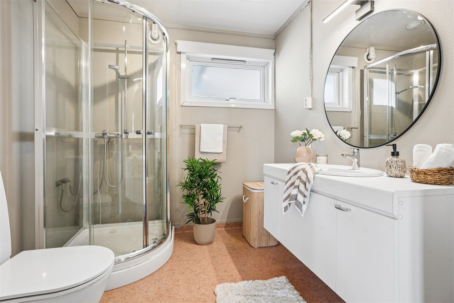 Badet i 1. etasje består av servant med underskap, dusjkabinett og toalett. I tillegg er det opplegg for vaskemaskin.