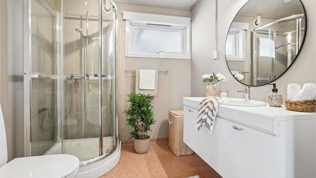 Badet i 1. etasje består av servant med underskap, dusjkabinett og toalett. I tillegg er det opplegg for vaskemaskin.