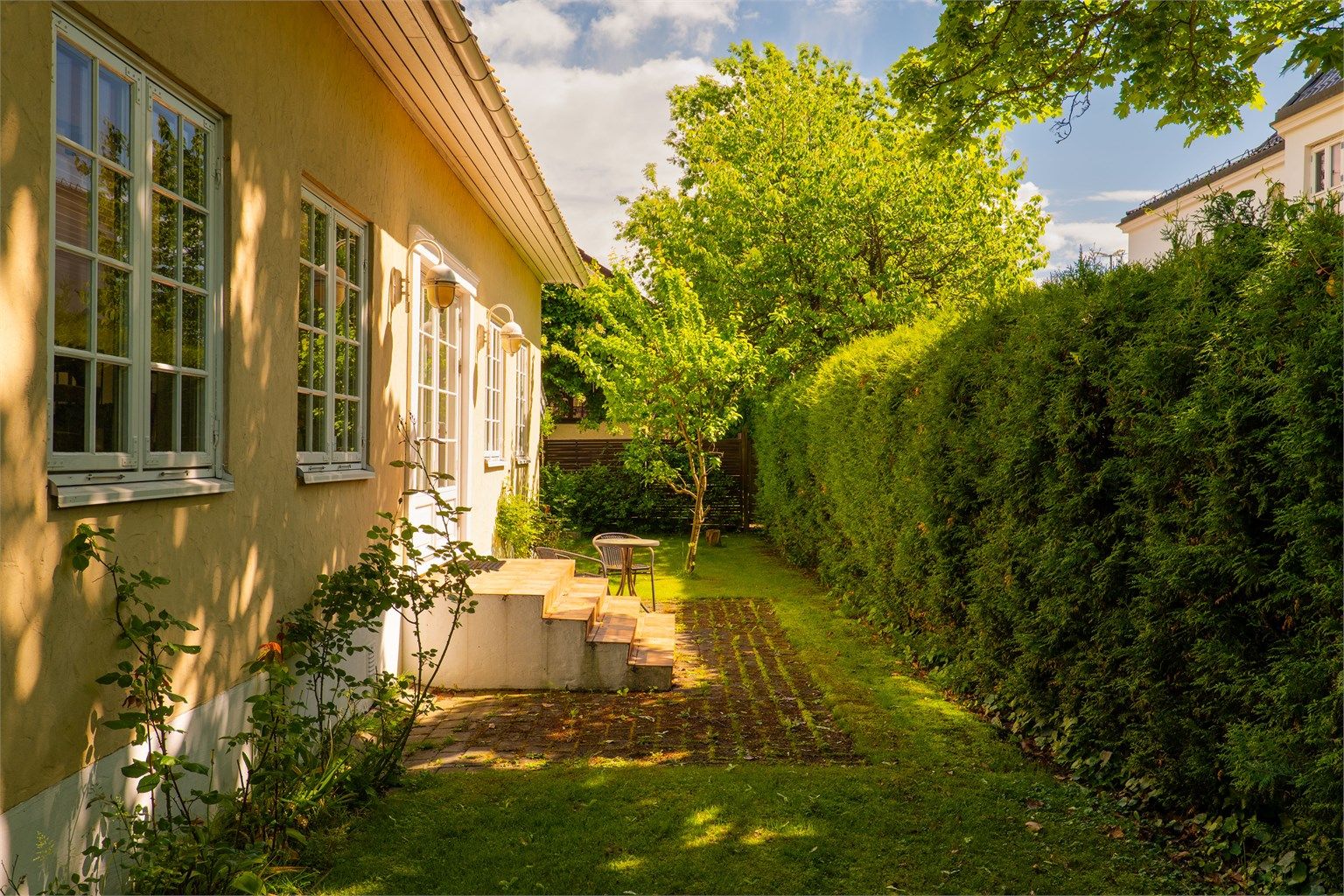 Hagen omfavner alle boligens fire sider. Til verandaen og altanen kommer solen fra utpå ettermiddagene sommerstid.