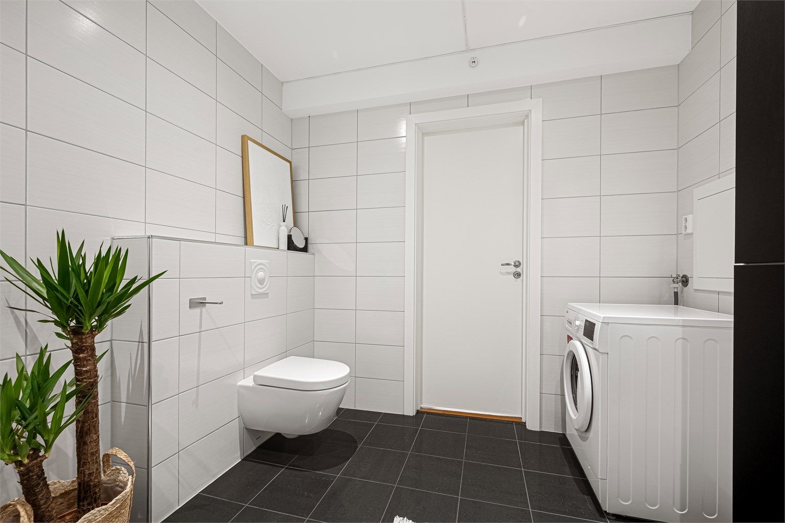 Badet er romslig med opplegg for vaskemaskin. 