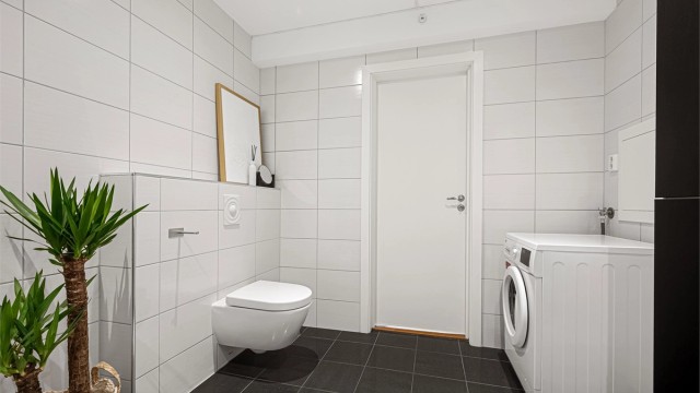 Badet er romslig med opplegg for vaskemaskin.
