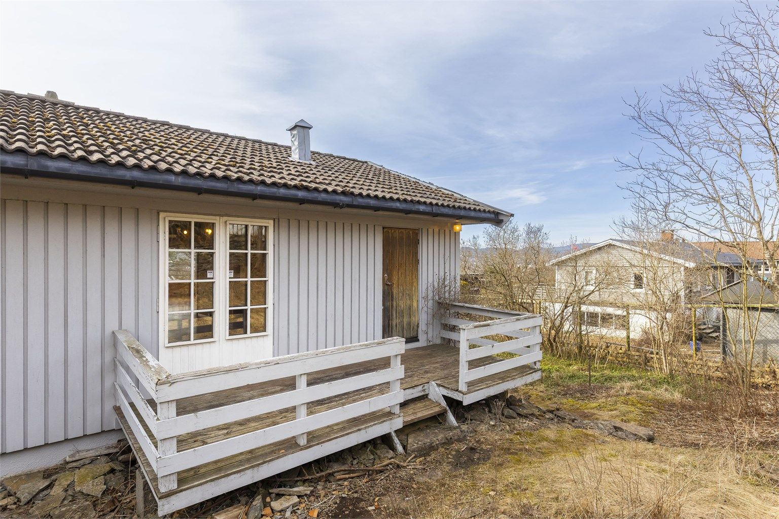 10 kvm veranda baksiden av huset. Inngang til kjøkken og spisestue fra denne siden av boligen.