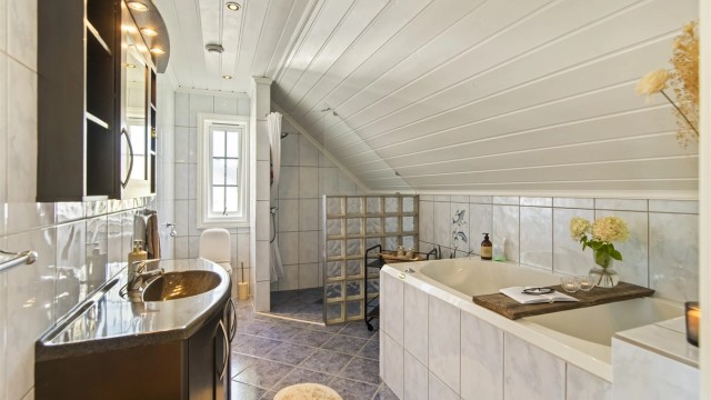 Badet er flislagt med varmekabler i gulv og downlights i tak