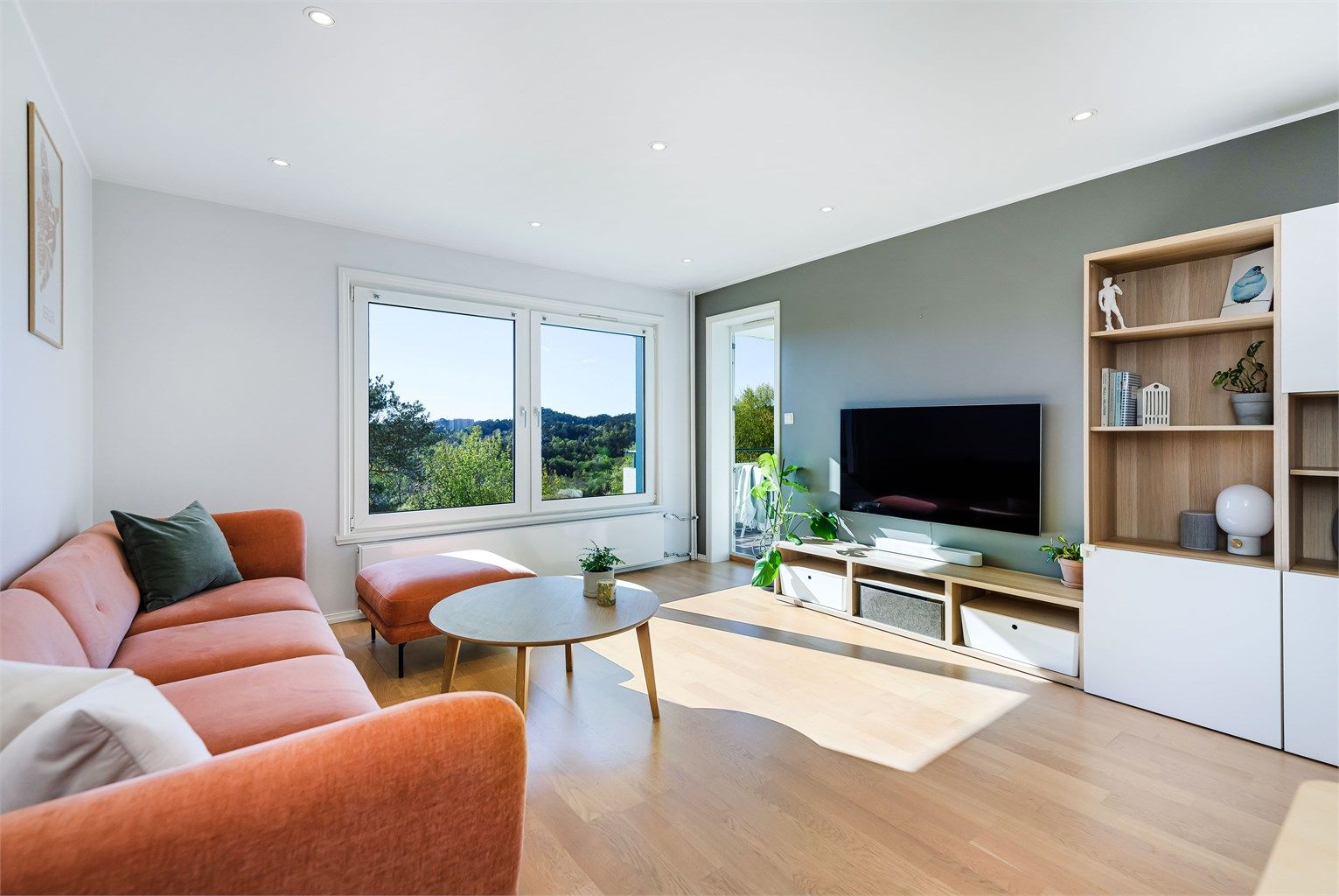 Store vinduer og mange downlights i taket gir godt lys til rommet.