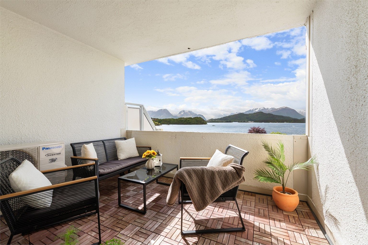 Lun og solrik balkong med nydelig utsikt mot fjord og fjell. 