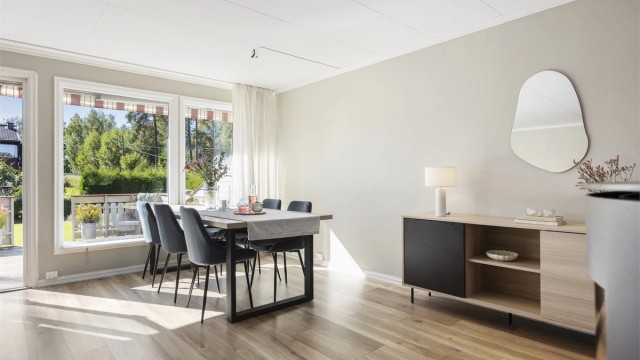 Spiseplass i stuen med store vindusflater som slipper inn rikelig med dagslys.
