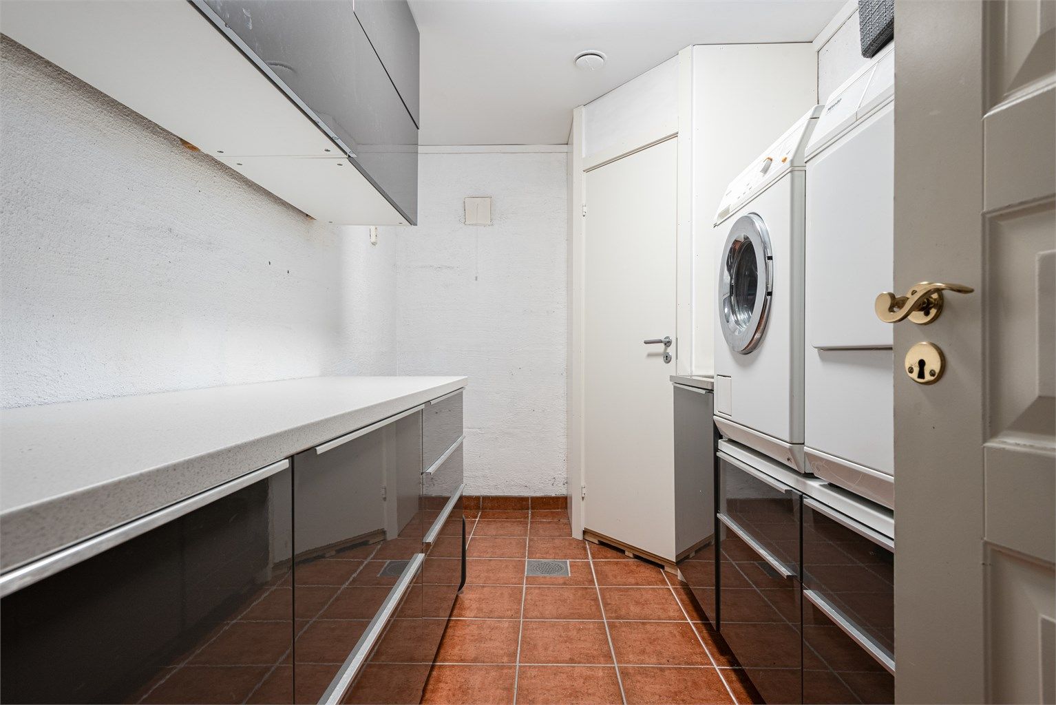 Eget praktisk vaskerom med gulvfliser med gulvvarme