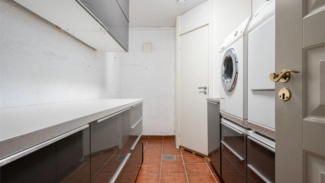 Eget praktisk vaskerom med gulvfliser med gulvvarme