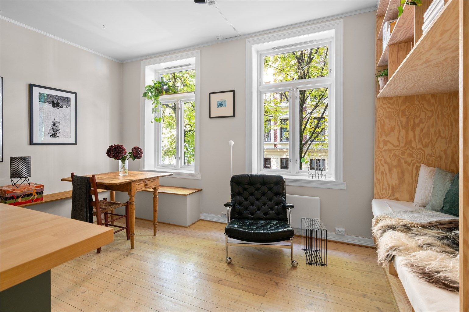 Stuen er holdt i tidsriktige nyanser som sammen med en stor vindusflate skaper en god atmosfære i leiligheten. 