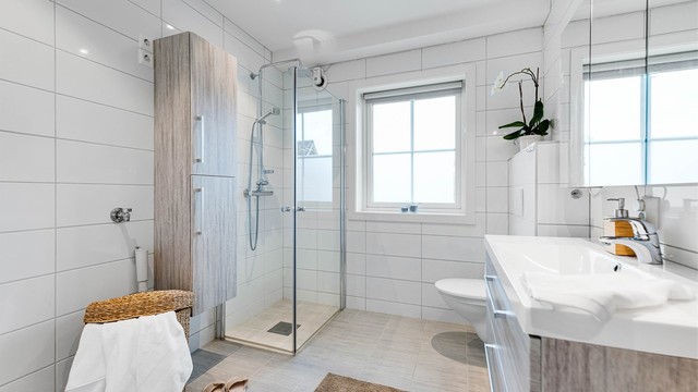 Badet er romslig, og er innredet med baderomsmøbler, vegghengt wc og dusjhjørne med dører. Gode oppbevaringsmuligheter både i speilskap, underskap og høyskap. Opplegg for vaskemaskin.