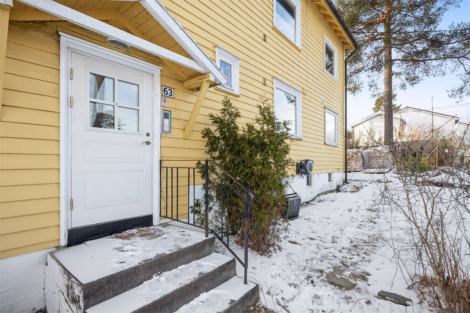 Fellestomten er opparbeidet med med asfalterte/grusede adkomstveier, plen, trær, lekeapparater og diverse beplantning.