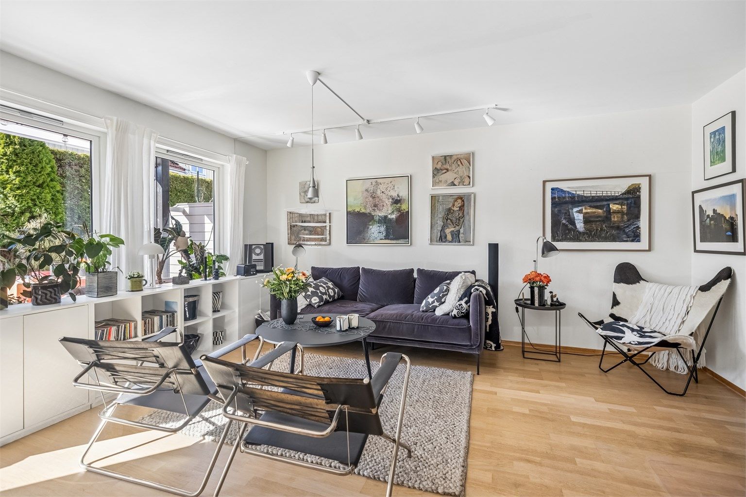 Lys og romslig stue med store vindusflater og terrassedør som gir godt med lysinnslipp.