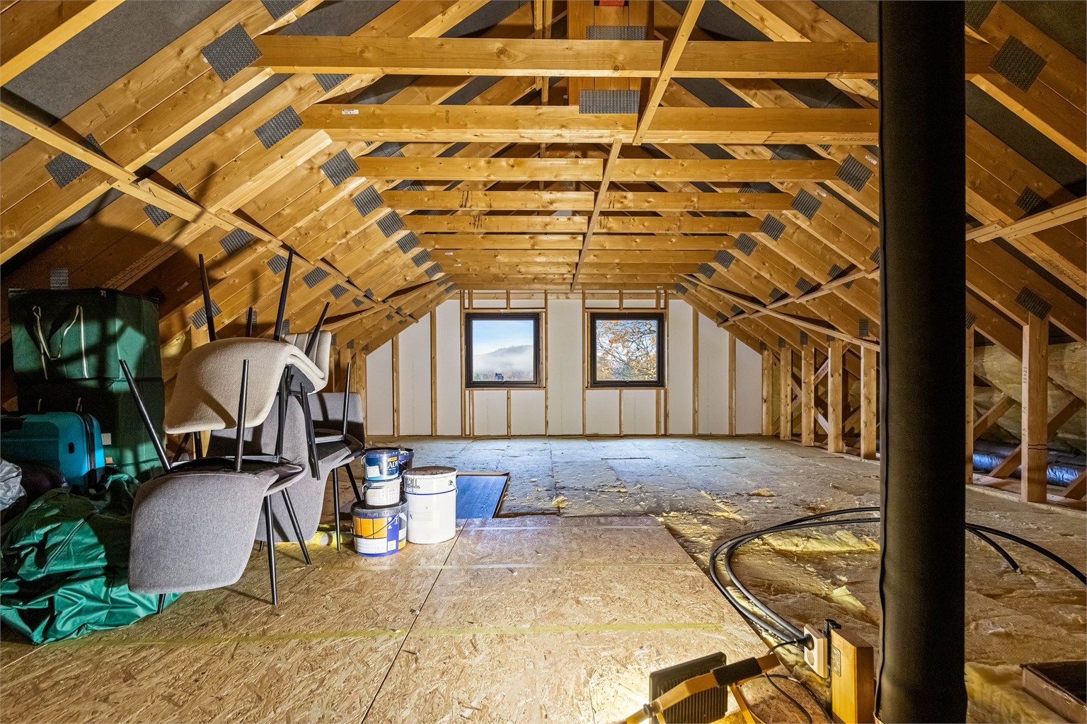 Uinnredet loft med delvis gulvet areal til lagring og mulighet for fremtidig innredning.