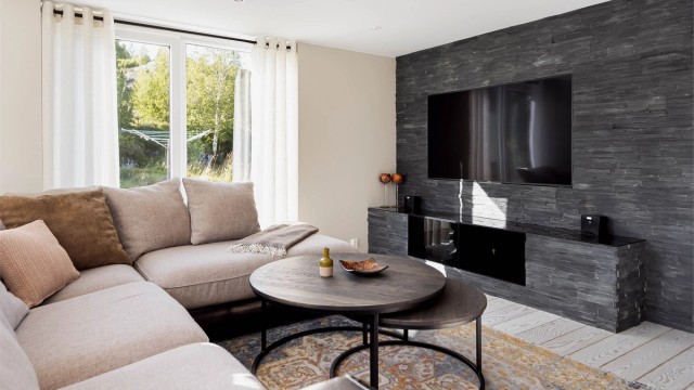 Særdeles lekker og eksklusiv tv-vegg på stuen med skifersten og innebygd tv, samt plassbygd tv-benk.