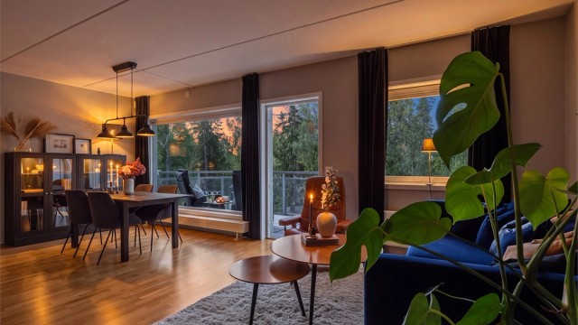 Stue, spisestue og kjøkken i åpen løsning, som oppleves både romslig og innbydende, med god plass til både sofagruppe og spisebord.