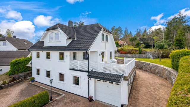 Enebolig med romslig utleieleilighet solrikt beliggende på en høyde med nydelig opparbeidet tomt.