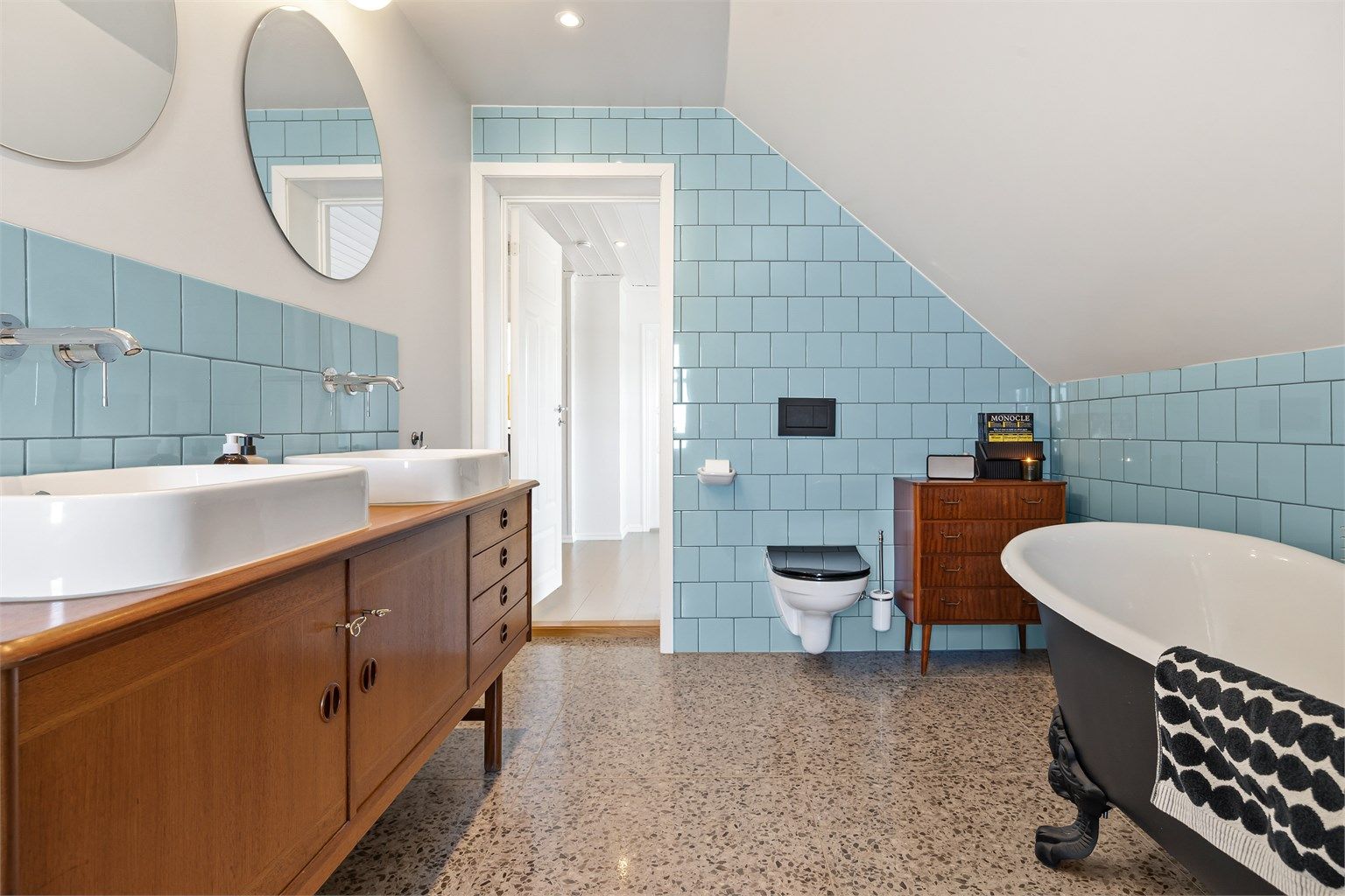 Badet er utstyrt med vegghengt toalett og rør-i-rør-system. Mekanisk avtrekksvifte i veggen sikrer god ventilasjon.