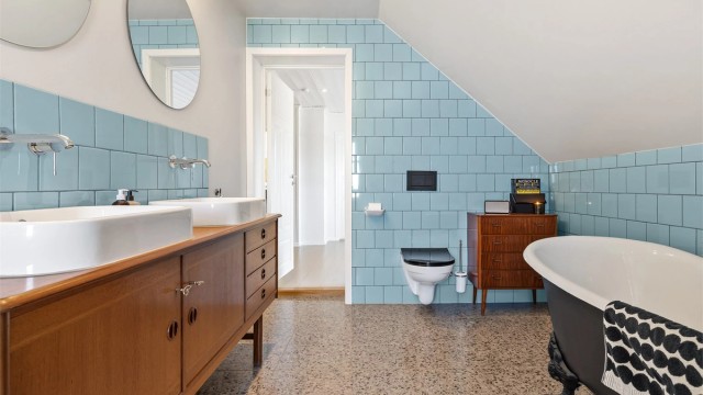 Badet er utstyrt med vegghengt toalett og rør-i-rør-system. Mekanisk avtrekksvifte i veggen sikrer god ventilasjon.