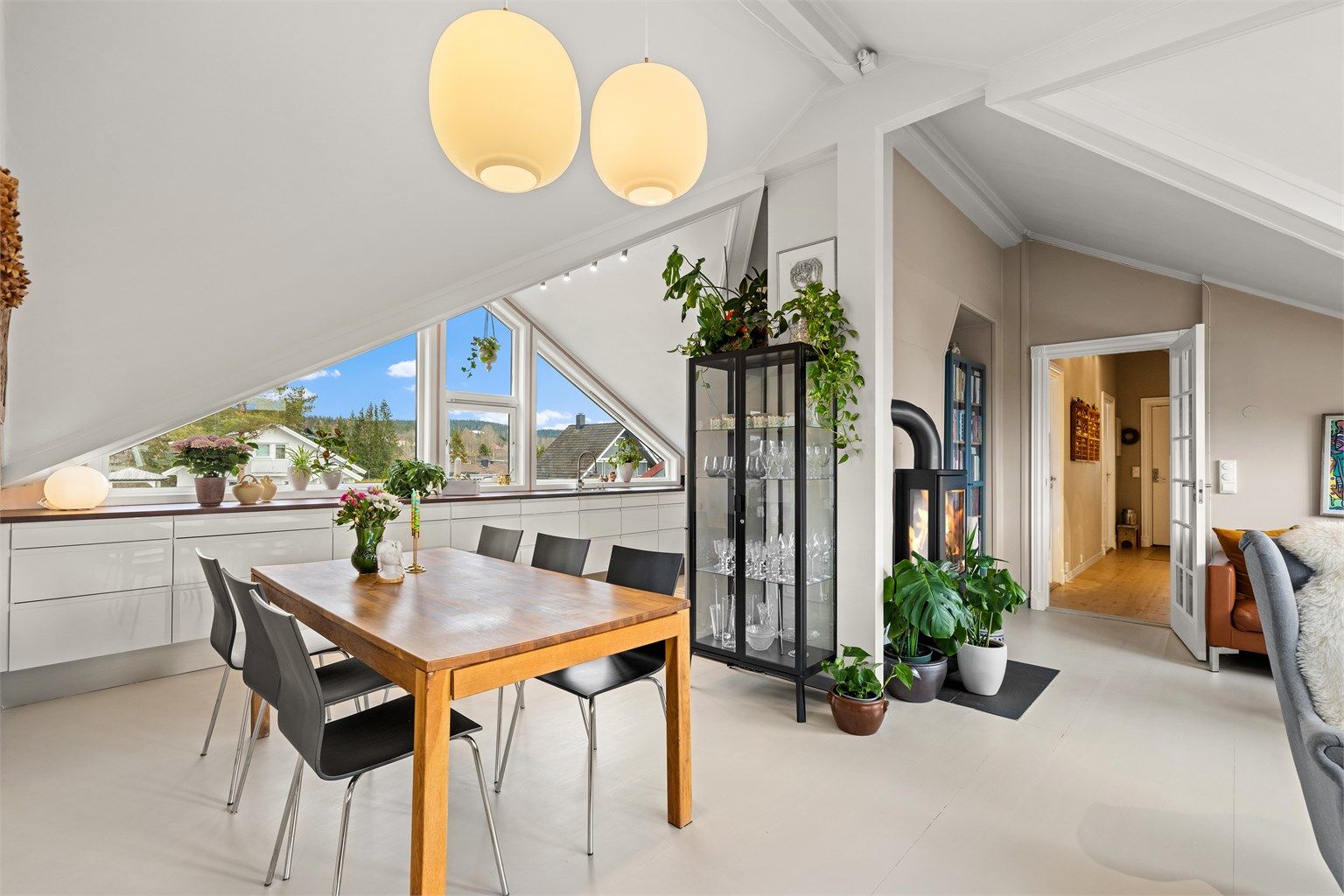 Fra spisestuen ser man over til stuedelen og peisovnen, noe som binder rommene sammen.