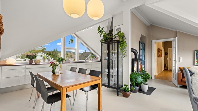 Fra spisestuen ser man over til stuedelen og peisovnen, noe som binder rommene sammen.