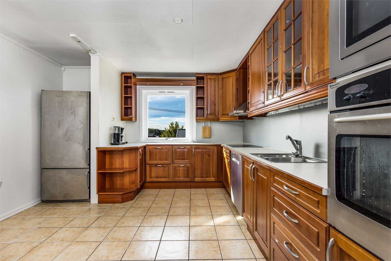 Flislagt kjøkken med integrerte hvitevarer