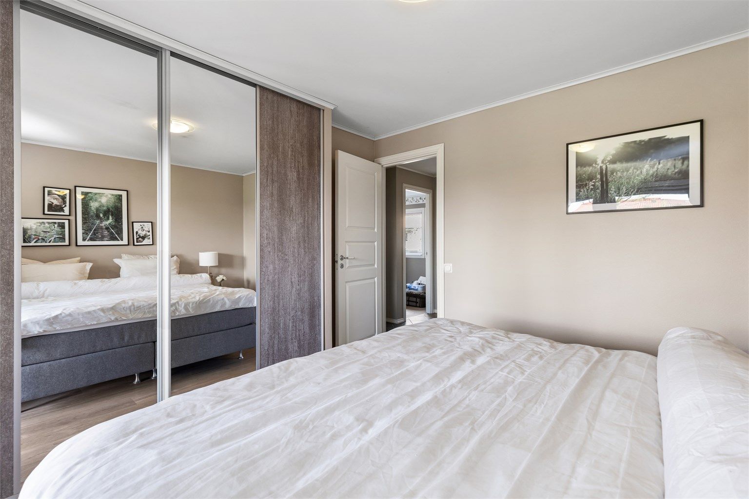 Rommet har god plass til dobbeltseng og rikelig med oppbevaring i en stor skyvedørsgarderobe.