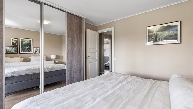 Rommet har god plass til dobbeltseng og rikelig med oppbevaring i en stor skyvedørsgarderobe.