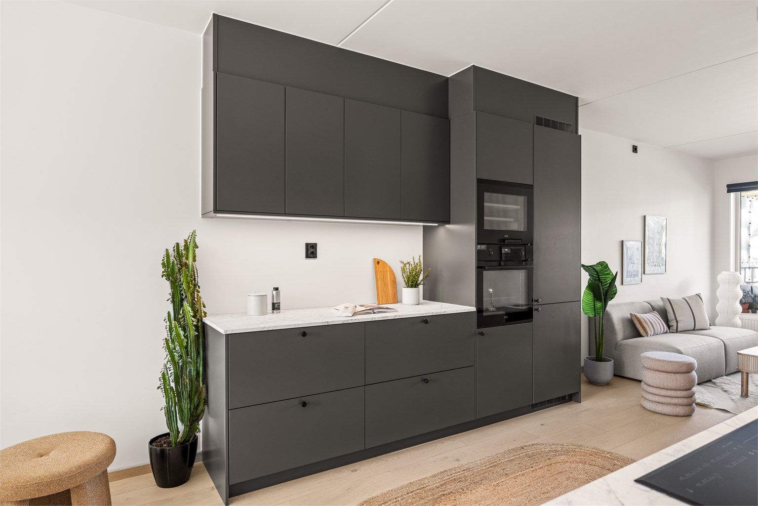 Leilighetens kjøkken er moderne og består av slette fronter og en laminert benkeplate. 