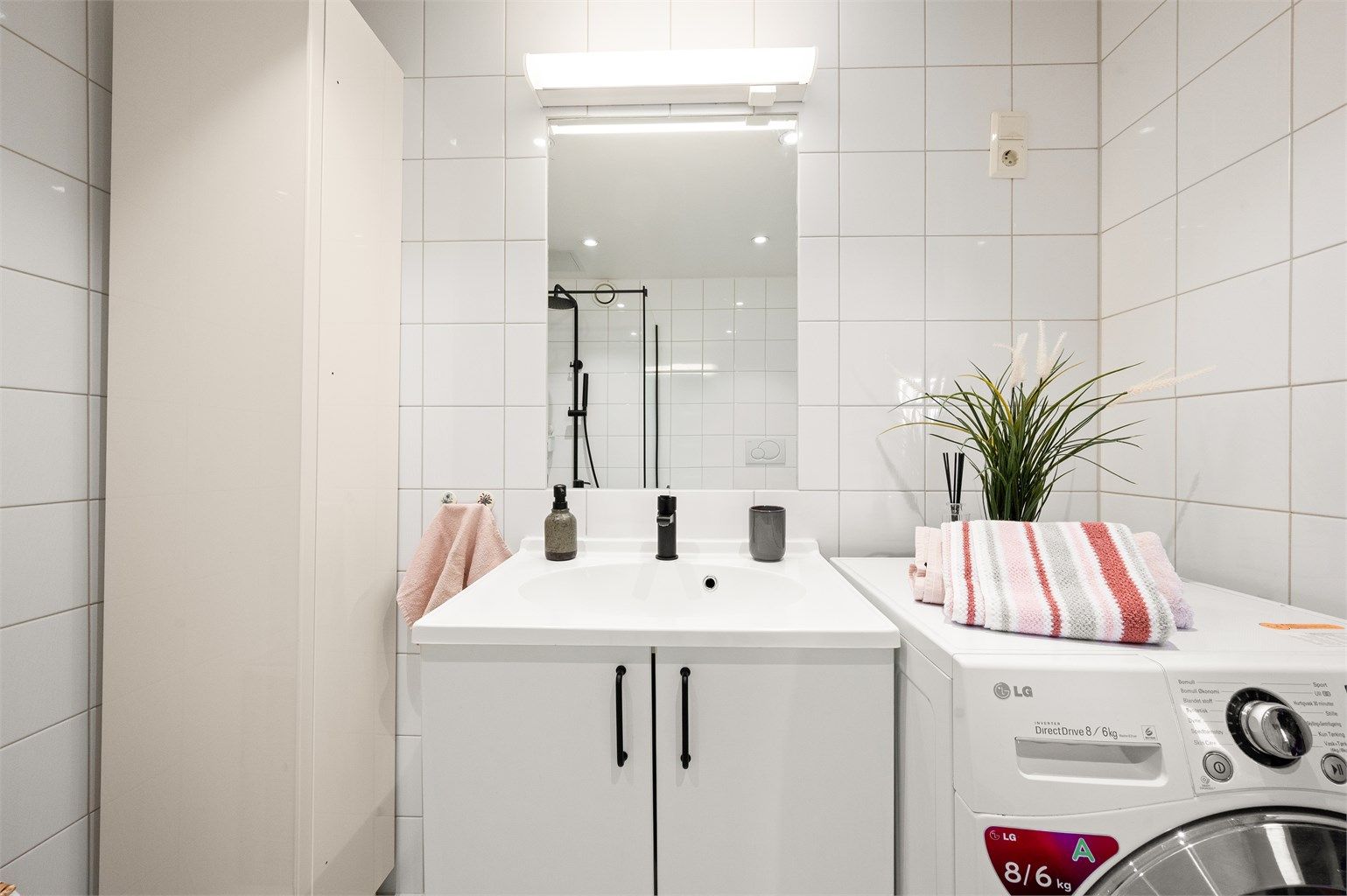 Badet er innredet med vegghengt toalett, servant nedfelt i innredning og dusjhjørne med glassvegg. Videre er det opplegg for vaskemaskin og balansert ventilasjon, noe som bidrar til et funksjonelt og godt inneklima.
