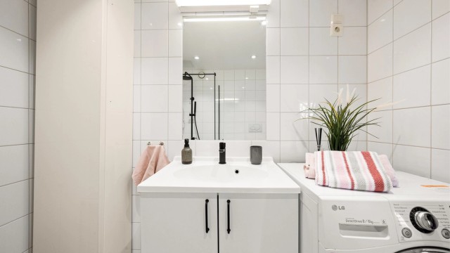 Badet er innredet med vegghengt toalett, servant nedfelt i innredning og dusjhjørne med glassvegg. Videre er det opplegg for vaskemaskin og balansert ventilasjon, noe som bidrar til et funksjonelt og godt inneklima.