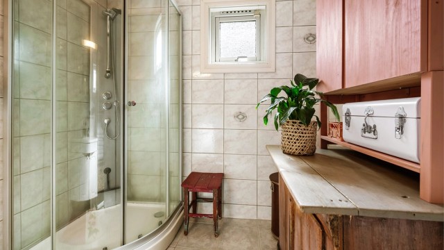 Badet er innredet med servantskap og dusjkabinett.