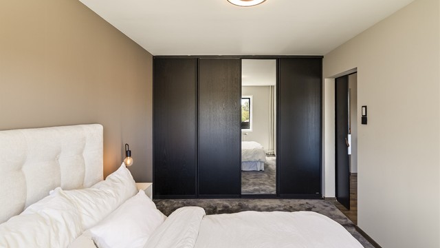 En stor skyvedørsgarderobe med speilfronter gir rikelig med oppbevaringsplass.