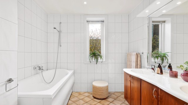 Bad 1 er delt opp med vaskerom i fremste del med skyvedør videre inn til selve badet