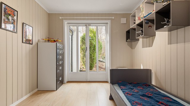 Soverom 2 har terrassedør vendt ut mot hyggelig uteområde med platting