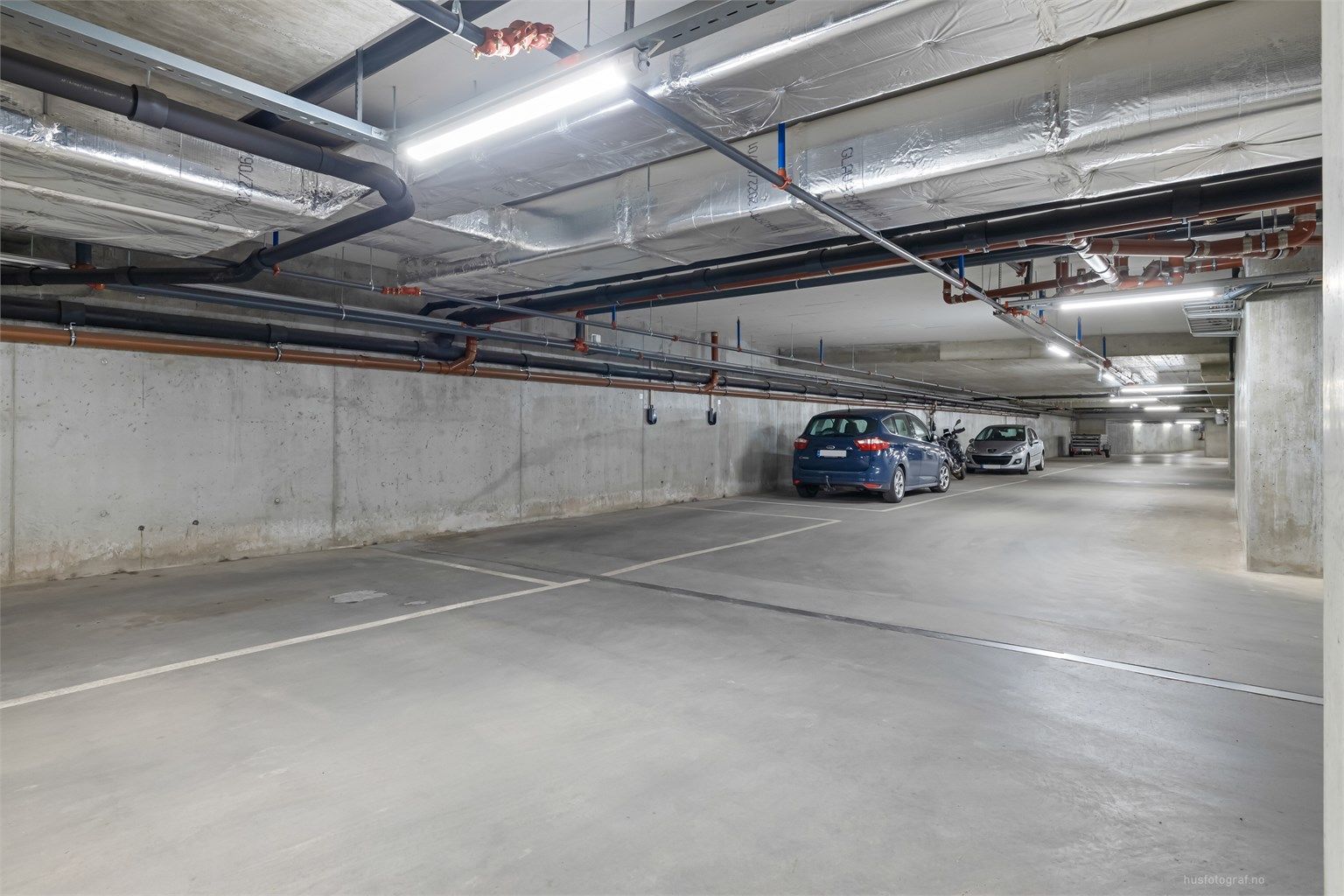 Medfølgende parkeringsplass i felles garasje - Tilrettelagt for etablering av ladeboks til el-bil.