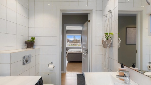 Badet er utstyrt med servantinnredning, speil med overlys og vegghengt toalett.
