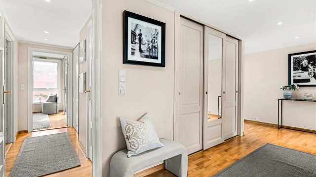 Romslig entré/gang med gulvvarme og skyvedørsgarderobe med god plass til yttertøy